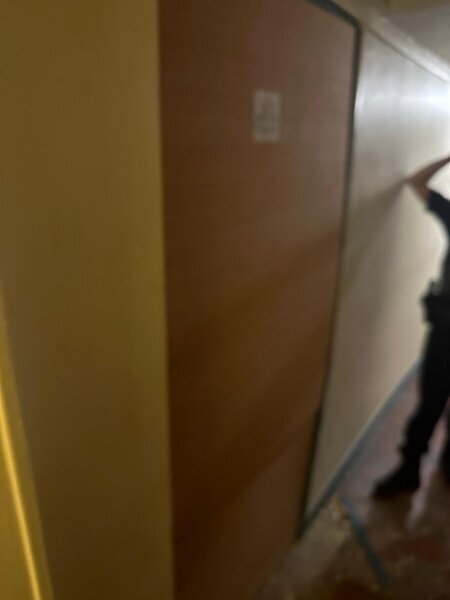 Serrurier intervenant dans un couloir pour ouvrir une porte palière verrouillée en urgence