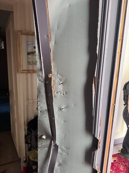 Porte intérieure fortement endommagée après effraction, bois éclaté et zone de serrure arrachée