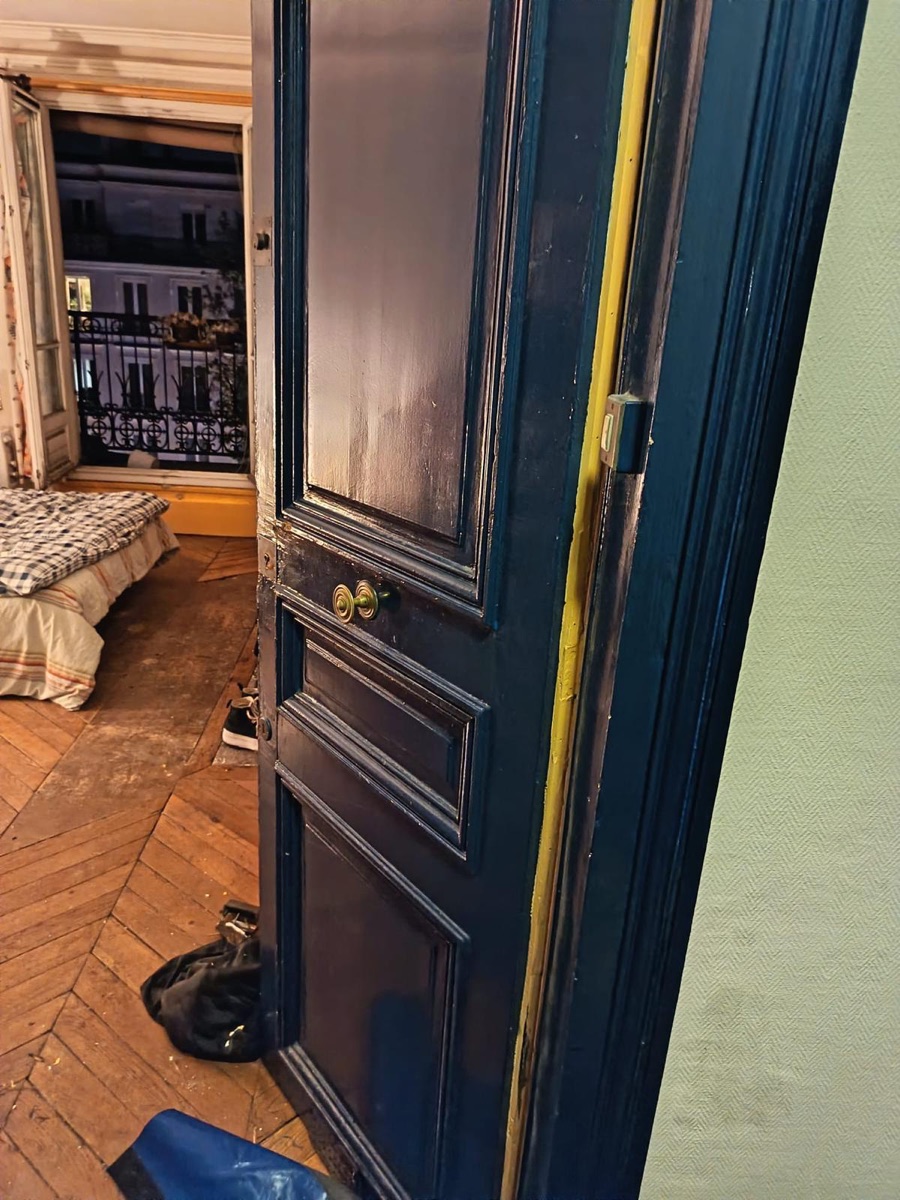 Porte parisienne à moulures ouverte après intervention, gâche neuve posée sur le bâti