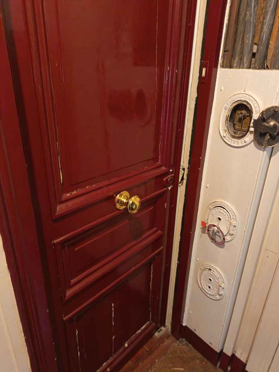 Porte parisienne ancienne à bouton laiton sur un palier haussmannien